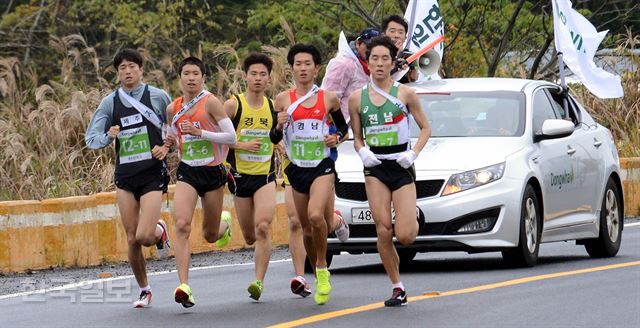 [저작권 한국일보]한반도통일 대역전 경주대회 첫날인 17일 제 3소구인 함덕리-조처리 구간을 선수들이 갈대숲을 뒤로한 채 역주하고 있다. 제주=고영권기자youngkoh@hankookilbo.com