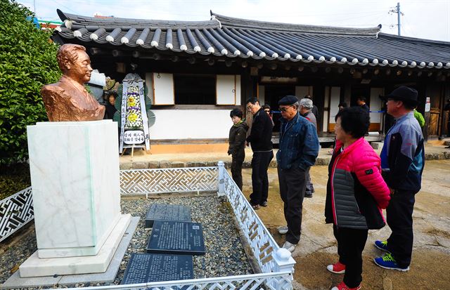 김영삼 전 대통령의 서거 소식이 전해진 22일 오전 경남 거제시 장목면 외포리 김 전 대통령 생가를 찾은 추모객들이 김 전 대통령 흉상 앞에서 고인을 추억하고 있다. 거제=전혜원기자 iamjhw@hankookilbo.com