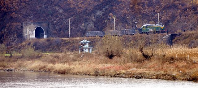 두만강변을 따라 설치된 철로에서 북한 기차가 터널을 통과해 지나가고 있다.