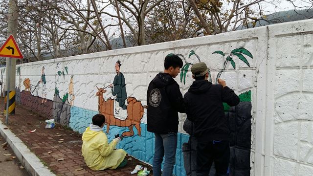 창원대 봉사단이 산청군 시천면 일원에서 마을벽화 그리기 봉사를 펼치고 있다. 창원대 제공