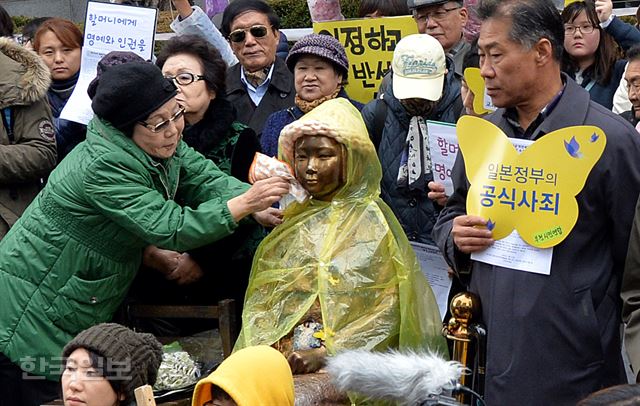 지난 25일 주한일본대사관 앞에서 열린 '일본군 위안부 문제 해결을 위한 정기 수요시위'에서 참석한 한 할머니가 소녀상에 묻은 빗물을 닦고 있다. 서재훈기자 spring@hankookilbo.com