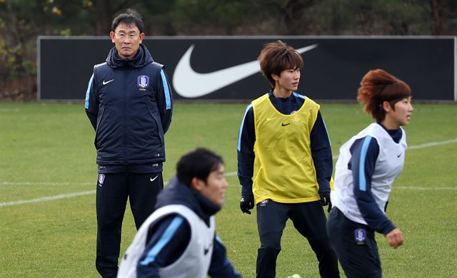 윤덕여(왼쪽)여자축구 대표팀 감독이 24일 경기 파주 축구국가대표트레이닝센터(NFC)에서 선수들을 지켜보고 있다. 대표팀은 29일 호주와 평가전을 치른다. 파주=연합뉴스