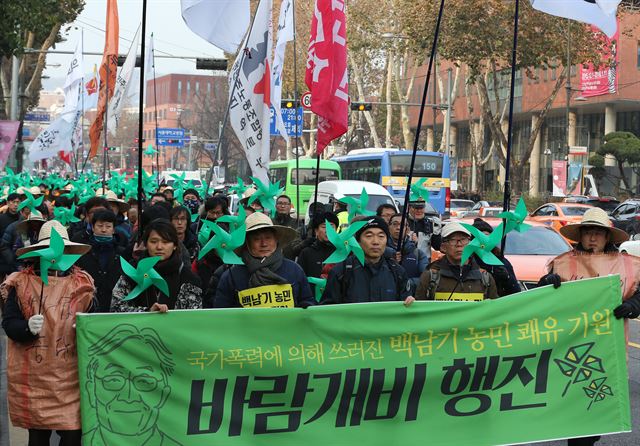 백남기대책위원회 관계자들이 28일 서울대학교 병원 앞에서 백남기(69)씨의 쾌유를 기원하는 바람개비를 들고 거리행진을 하고 있다. 백 씨는 지난 '민중총궐기' 시위에 참석했다가 경찰의 물대포에 맞고 중태에 빠졌다. 연합뉴스