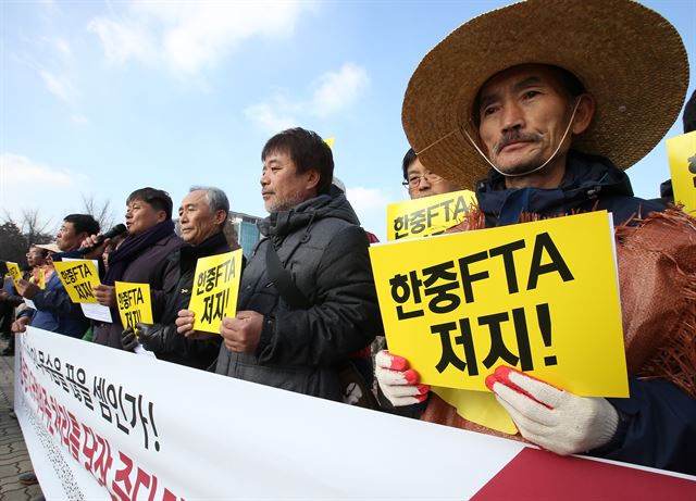 30일 오전 전국농민회총연맹 등 시민단체 회원들이 서울 여의도 국회 앞에서 한중 FTA 국회비준 처리 중단을 촉구하며 기자회견을 하고 있다. 연합뉴스