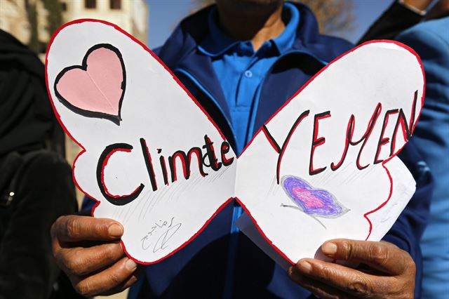 제21차 파리 유엔기후변화협약 당사국총회(COP21) 공식 개막을 하루 앞둔 29일 예멘 사나에서 한 시민이 '예멘과 기후'라는 문구가 쓰인 플래카드를 들고 기후변화 대책 촉구 시위에 나서고 있다. 사나=EPA 연합뉴스