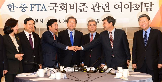 여야 지도부가 30일 한중 FTA 비준동의안 처리를 위한 협상을 타결지은 뒤 원유철(왼쪽 세번째) 새누리당 원내대표와 이종걸(오른쪽 두 번째) 새정치민주연합 원내대표가 악수하고 있다. 왼쪽부터 나경원 국회 외통위원장, 김정훈 새누리당 정책위의장, 김무성 대표, 문재인 새정치연합 대표, 최재천 정책위의장. 오대근기자 inliner@hankookilbo.com