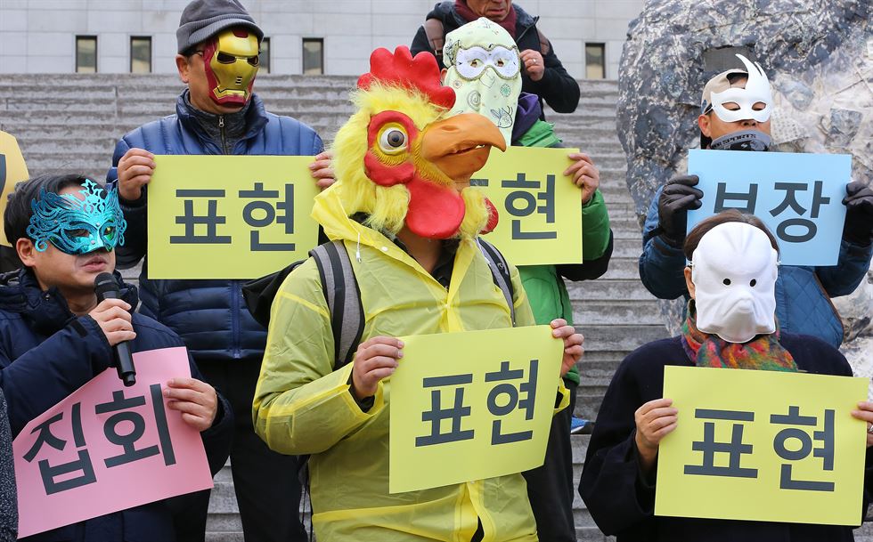 5일 오후 서울 세종로 세종문화회관 계단에서 열린 '집회, 결사 표현의 자유를 위한 예술행동 액숀가면'의 퍼포먼스에서 일부 참가자들이 'IS'가 쓰여진 가면을 쓰고 있다 .연합뉴스