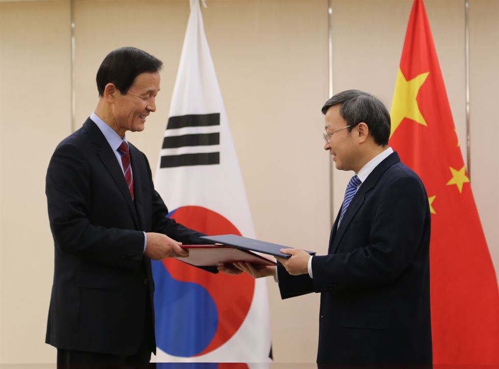 9일 중국 베이징에서 김장수(왼쪽) 주중대사와 중국의 왕서우원 상무부 부부장이 한중 FTA의 20일 발효를 공식 확정하는 외교공한을 교환하고 있다. 베이징=연합뉴스