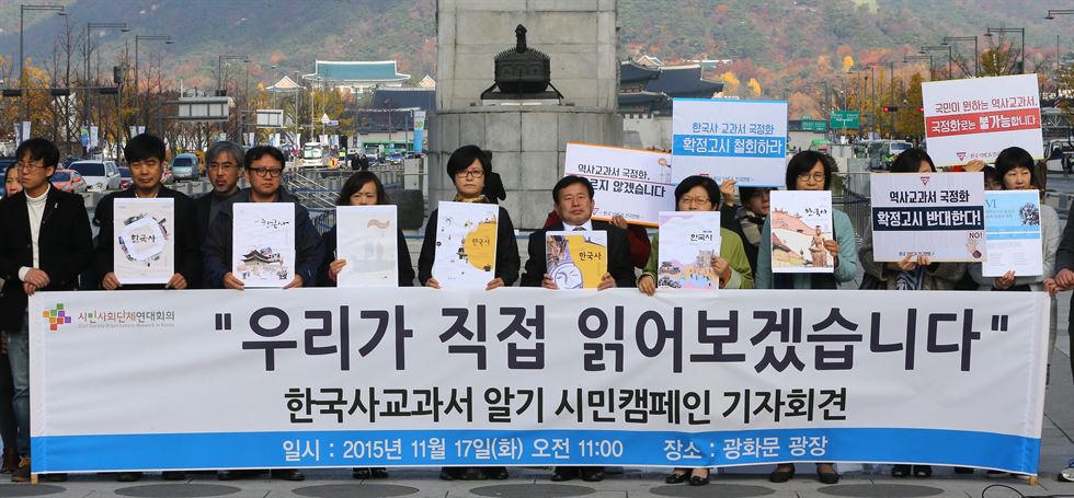 지난달 17일 오전 서울 광화문 광장에서 열린 한국사교과서 알기 "우리가 직접 읽어보겠습니다" 시민캠페인 기자회견에서 시민단체연석회의 대표자들이 현행 8종 역사교과서 모형을 들고 기자회견문을 낭독하고 있다. 연합뉴스