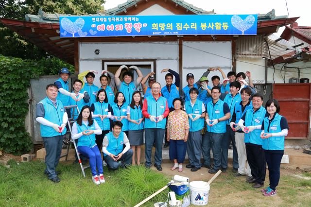 현대제철 임직원들이 충남 당진시에서 ‘희망의 집수리’ 봉사활동을 펼친 뒤 두 손으로 하트 모양을 만들어 포즈를 취했다. 현대제철 제공