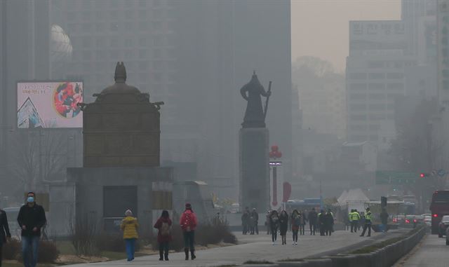 안개와 미세먼지 농도가 짙어진 휴일인 3일 서울 광화문광장에서 시민들이 걸어가고 있다. 연합뉴스