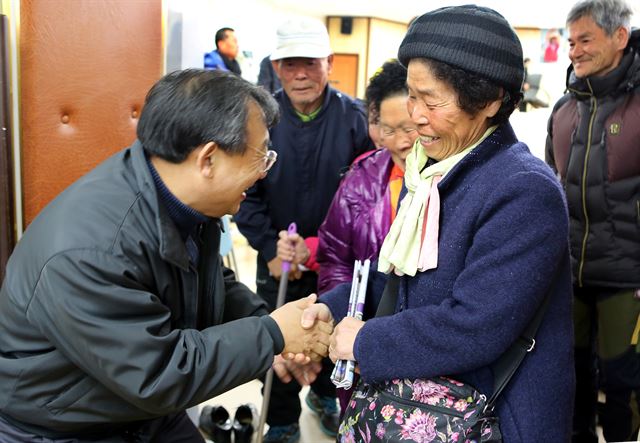 이정현(왼쪽) 새누리당 의원이 지난달 30일 전남 순천 송광면 주민복지센터에서 열린 의정보고회에서 지역 주민들과 인사를 나누고 있다. 이정현의원실 제공