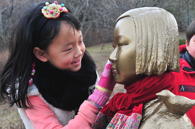 6일 오후 포항시 북구 환호해맞이 공원 내 소녀상 앞에서 열린 수요집회 24주년 맞이 세계연대행동에서 한 어린이가 소녀상을 어루만지고 있다. 이날 회원들은 아베정부의 공식사과와 법적배상이 빠진 정부간 합의는 무효라고 주장하고,일본 대사관 앞 소녀상 철거를 거론하는 일본 정부는 위안부 피해할머니들 앞에 무릅을 꿇고 사죄해야 한다고 주장했다. 뉴스1