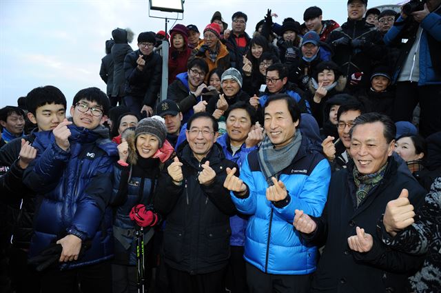 박원순(앞줄 왼쪽에서 세번째) 서울시장이 1일 서울 서대문구 안산 봉수대에 올라 권오중(박 시장 뒷줄 오른쪽)전 서울시장 비서실장과 함께 일출을 보러 온 시민들과 손가락으로 하트 모양을 만들고 있다. 서울시 제공