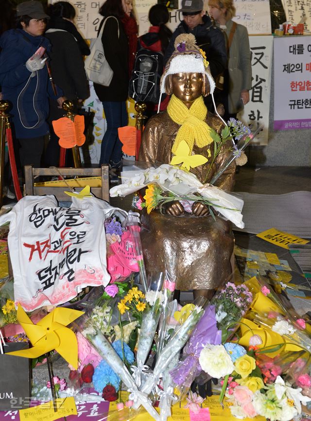 [ [저작권 한국일보]9일 오후 서울 종로구 옛 일본대사관 앞에서 열린 일본군 '위안부' 문제 토요시위가 끝난후 평화의 소녀상은 참석자들이 헌화꽃으로 가득 찼다.2016.1.9신상순 선임기자ssshin@hankookilbo.com /2016-01-09(한국일보)