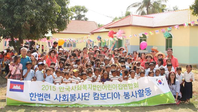 한국사회복지법인 어린이집연합회 회원들로 구성된 자원봉사단원들과 캄보디아 현지 어린이 등이 최근 준공한 어린이집 앞에서 기념촬영을 하고 있다.