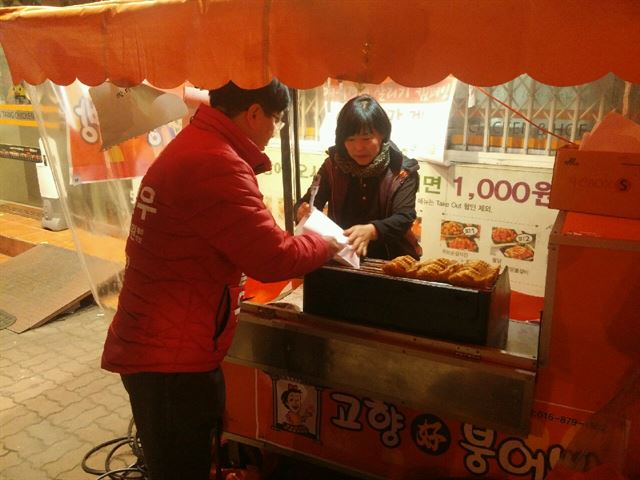 대구 달서구병 선거구 새누리당 예비후보인 이철우 변호사가 점심으로 붕어빵을 사먹고 있다. 이철우 예비후보 제공/2016-01-11(한국일보)