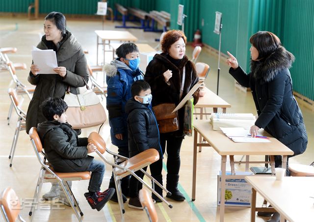 13일 오후 서울 용산구 이태원초등학교에서 예비 초등학생이 학부모와 함께 접수를 하고 있다. 홍인기기자 hongik@hankookilbo.com