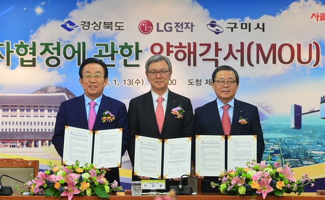 13일 김관용(왼쪽) 경북도지사와 이상봉(가운데) LG전자 사장, 남유진 구미시장이 경북도청에서 LG전자의 태양광 신규 생산라인 투자양해각서에 서명한 뒤 기념촬영을 하고 있다. LG전자 제공