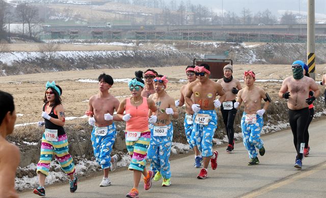 대관령 알몸마라톤 대회 참가자들이 17일 잠옷 바지와 바디페인팅 차림으로 강원 평창군 도로를 달리고 있다. 이 대회는 이색복장상을 수여한다. 평창=연합뉴스