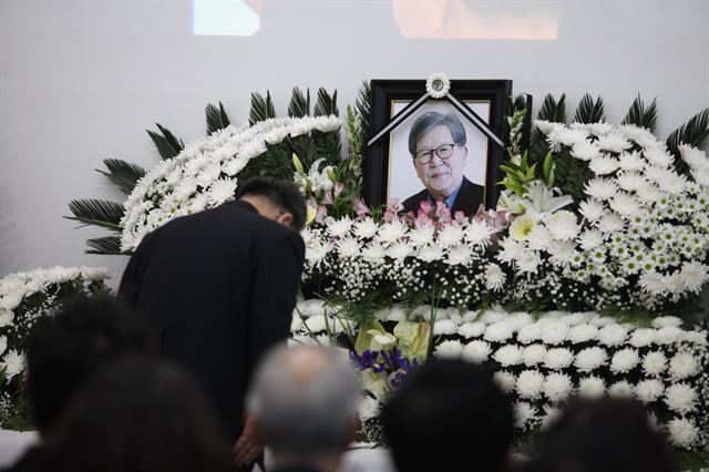 18일 서울 구로구 성공회대 대학성당에서 엄수된 고 신영복 성공회대 석좌교수 영결식에서 한 조문객이 고인의 영정 사진 앞에서 묵념하고 있다. 성공회대 제공