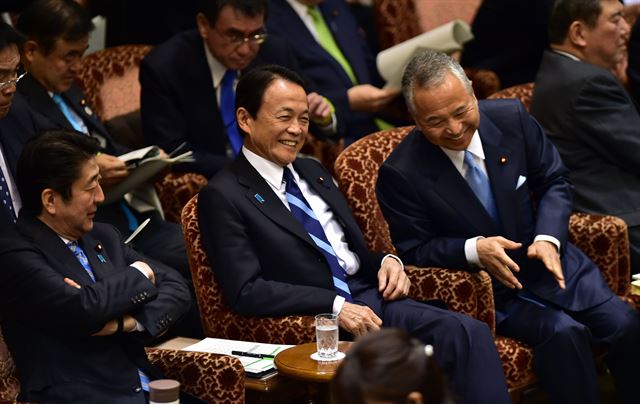 중국 경기둔화, 통화급락, 유가폭락으로 세계 경제가 요동치면서 안전 자산인 금과 미국 국채 그리고 일본 엔화 에 대한 투자가 증가하고 있는 가운데 21일(현지시간) 일본 도쿄에서 참의원 결산위에 출석한 아베 신조 일본 총리, 아소 다로 부 총리 겸 재무상, 아마리 아키라 일본 경제재생담당상이 나란히 앉아 회의가 시작되기를 기다리며 대화를 하고 있다. 한편, 아베 신조 일본 총리의 측근인 아마리 아키라 일본 경제재생담당상이 정치자금 문제로 궁지에 몰리고 있다. 도쿄=AFP 연합뉴스