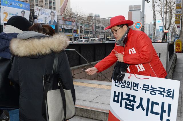 서울 양천갑 새누리당 예비후보로 등록한 이기재 후보가 한파가 몰아친 21일 오전 양천구 오목교역 입구에서 출근길 시민들에게 맨손으로 명함을 건네며 인사하고 있다. 선거법상 예비후보는 지하철 역사 안에 들어가서 선거운동을 할 수 없다. 오대근기자 inliner@hankookilbo.com