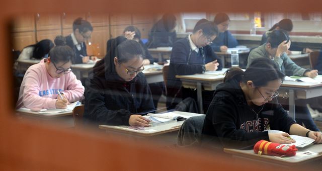 가구 소득이 높을수록 대학수학능력시험 성적도 높으며 그 배경에는 학부모의 경제력으로 뒷받침되는 사교육이 작용한다는 분석 결과가 나왔다. 사진은 2016년도 수능시험일인 12일 오전 서울 종로구 풍문여고에서 수험생들이 시험 준비를 하고 있는 모습. 한국일보 자료사진