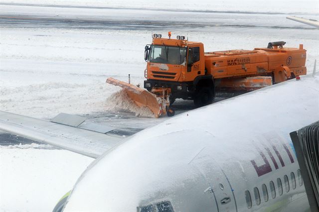 25일 오전 폭설과 강풍으로 항공기 운항이 사흘째 중단된 제주국제공항 활주로에서 제설차가 제설작업을 하고 있다. 국토교통부는 이날 오후 8시 항공기 운항을 재개할 예정이다. 뉴시스