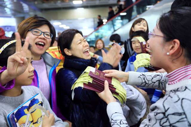 한파로 활주로가 폐쇄됐던 제주공항에 25일 오후부터 운항이 재개면서 중국행 항공권을 받아 든 중국인 관광객들이 기뻐하고 있다. 제주=연합뉴스