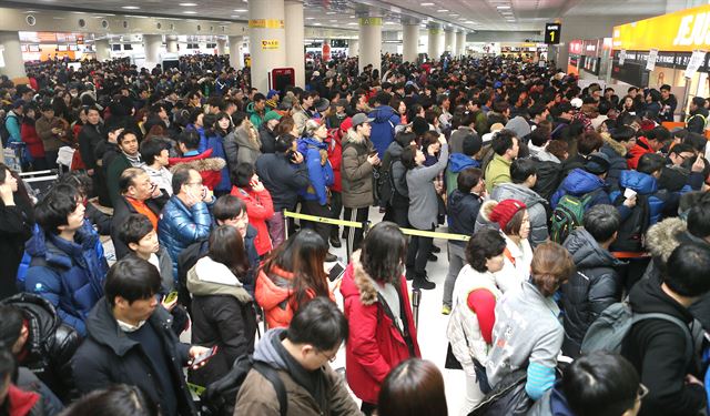 사상 초유의 제주공항 항공기 중단 사태가 3일째 이어진 25일 운항재개 결정이 난 가운데 제주공항 발권 카운터 앞이 발권을 하려는 수만명의 사람들로 북적이고 있다. 제주=연합뉴스