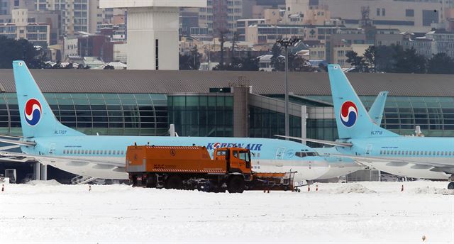 제주공항 항공기 운항 중단 조치가 25일 정오에 해제됐다. 사진은 이날 공항 재개에 앞서 한국공항공사 제주지역본부의 제설차량이 계류장에서 제설작업을 벌이고 있다. 연합뉴스