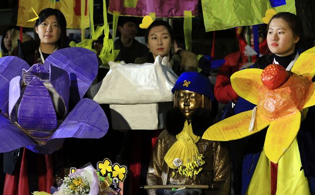 지난 30일 오후 서울 중학동 주한일본대사관 앞 소녀상에서 열린 한일 ‘위안부 합의’무효 요구 5차 토요시위에서 이날 ‘한일합의 무효선언 전국행동의 날’ 행진에 참가한 학생들이 꽃모양의 조형물 등을 들고 소녀상 옆에 자리하고 있다. 연합뉴스