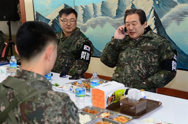 김무성 새누리당 대표가 1일 육군6사단 전방부대를 방문해 부대원과 오찬중 김대현이병(뒷모습)의 부모와 안부전화를 하고 있다. 오대근기자 inliner@hankookilbo.com