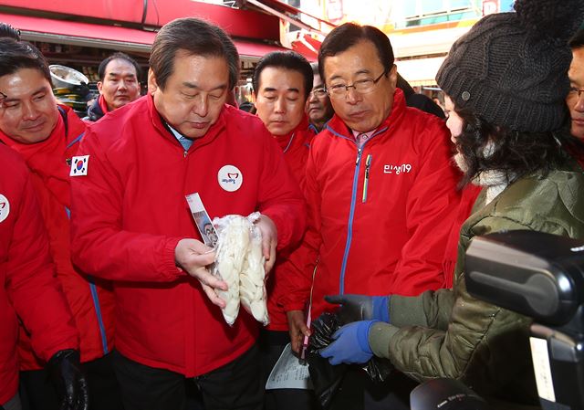 김무성 새누리당 대표가 2일 서울 남대문 시장에서 문화상품권으로 떡을 사고 있다. 연합뉴스