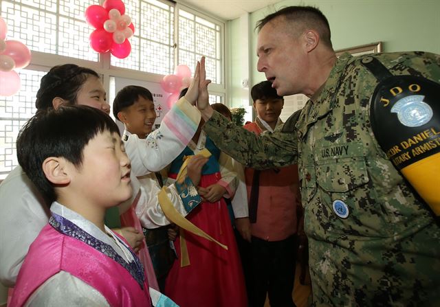 비무장지대(DMZ) 내 유일한 학교인 경기도 파주 대성동초등학교에서 4일 열린 47회 졸업식에서 학생들의 영어교사였던 미 해군 다니엘 맥셰인 소령이 졸업생들과 하이파이브를 하며 축하하고 있다. 사진공동취재단