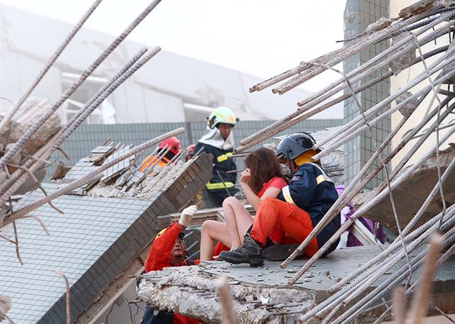 구조대원들이 무너진 건물에서 부상자를 옮기고 있다.