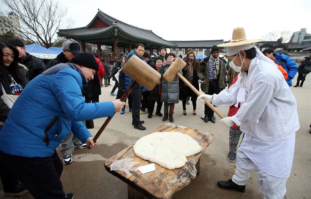 설날인 8일 오전 서울 남산골 한옥마을을 찾은 시민들이 떡 메치기 체험을 하고 있다. 연합뉴스