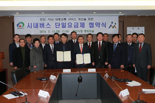 복기왕 아산시장(앞줄 왼쪽 네 번째 )과 구본영 천안시장(다섯 번째)은 12일 시내버스 단일요금제협약 했다. 아산시 제공