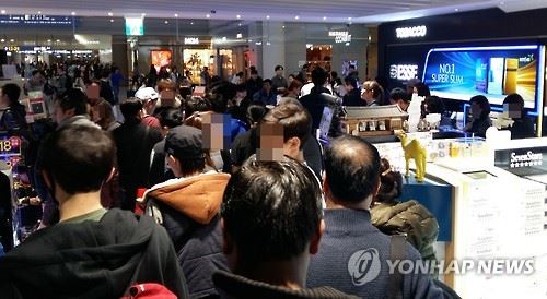 지난 3일 인천국제공항 면세점 담배판매 매장에서 해외출국 승객과 외국인들이 담배를 사고 있다. 연합뉴스