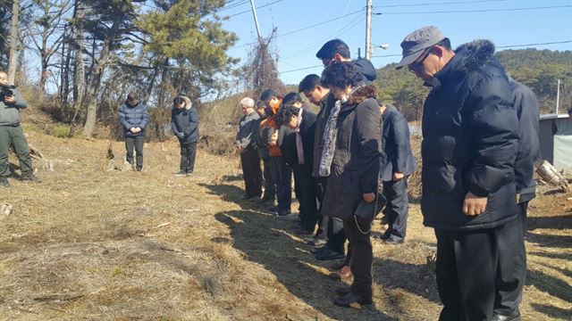 15일 선감학원 생존자와 경기도의회, 경기도 관계자들이 선감학원 옛터 맞은편의 공동묘지에서 묵념하고 있다. 이범구기자 ebk@hankookilbo.com