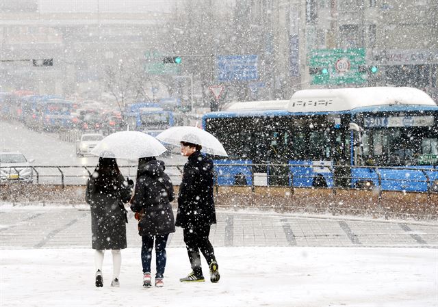 16일 오후 서울 중구 세종대로에서 함박눈이 내리는 가운데 시민들이 숭례문 앞을 지나가고 있다. 홍인기기자 hongik@hankookilbo.com