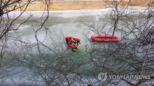 20일 오후 강원 홍천강에서 사륜오토바이를 타다 물에 빠진 윤모(47)씨를 119 구조대가 구조하고 있다. 연합뉴스.