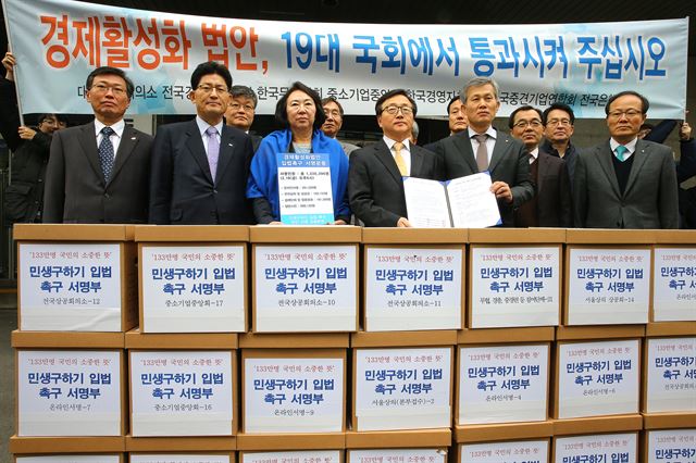 대한상의, 전경련, 중기협중앙회, 경총 등 경제단체 대표들이 22일 오전 서울 여의도 새누리당사 입구에서 '경제활성화' 법안 입법 촉구 서명부와 성명서를 들고 기념촬영을 하고 있다. 경제활성화 입법 촉구서에는 총 1,300,396명이 서명했다. 연합뉴스