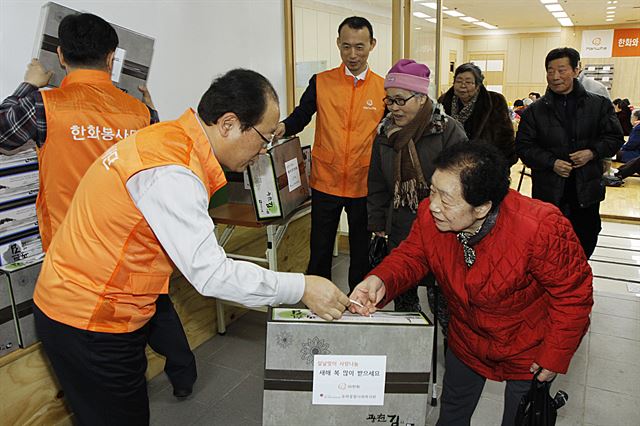 (주)한화 임직원들이 이달 3일 서울 중구 신당동 유락종합사회복지관을 찾아 지역 독거노인들에게 선물을 전달하고 있다.