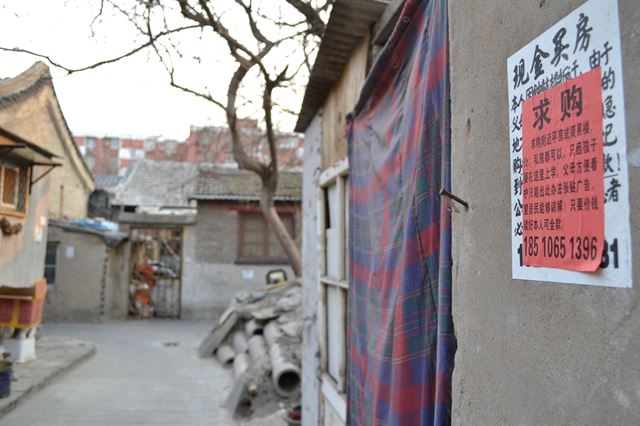 학군이 좋은 것으로 알려진 중국 베이징시 시청구의 한 골목길 낡은 집 벽에 집을 사고 싶다는 광고가 붙어 있다.