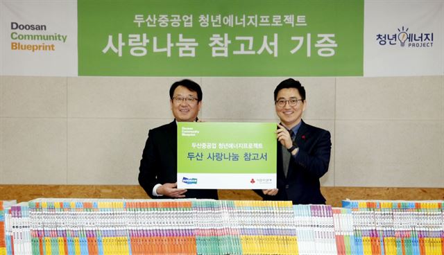 25일 오후 4시 경남 창원시 해피타임 지역아동센터에서 열린 '두산 사랑의 참고서'전달식에서 이한희(왼쪽) 두산중공업 CRS팀장이 박은덕 경남사회복지공동모금회 사무처장에게 참고서를 전달했다.