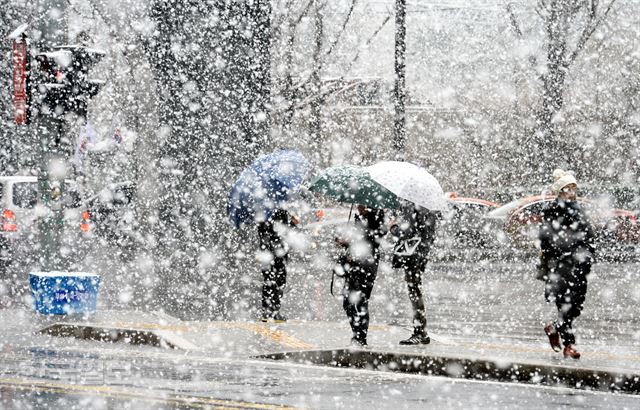 전국 곳곳에 대설 주의보가 내린 28일 오후 서울 서대문구 횡단보도에서 시민들이 우산을 쓴 채 신호를 기다리고 있다. 홍인기기자 hongik@hankookilbo.com