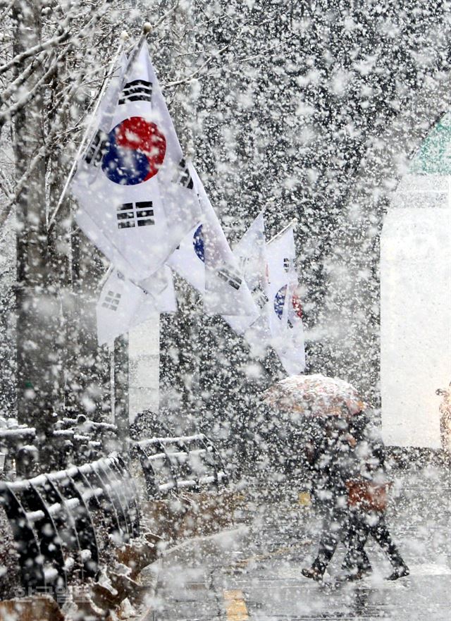 전국 곳곳에 대설 주의보가 내린 28일 오후 서울 서대문구에서 시민들이 함박눈이 쏟아지는 가운데 횡단보도를 건너고 있다. 홍인기기자 hongik@hankookilbo.com