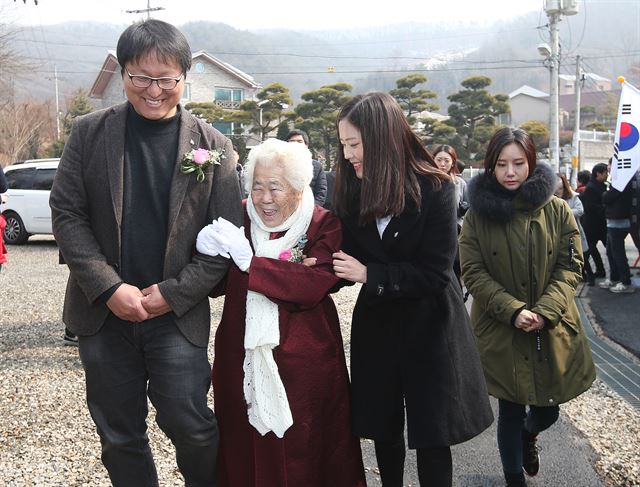 27일 오전 경기 광주시 퇴촌면 나눔의 집에서 열린 ‘일본군 위안부 피해자 추모제 및 추모관ㆍ유품 기록관’착공식에서 영화 ‘귀향’의 조정래 감독(왼쪽부터), 이옥선 할머니, ‘귀향’에 출연한 영화배우 최리씨가 팔짱을 끼고 행사장으로 향하고 있다. 광주=연합뉴스